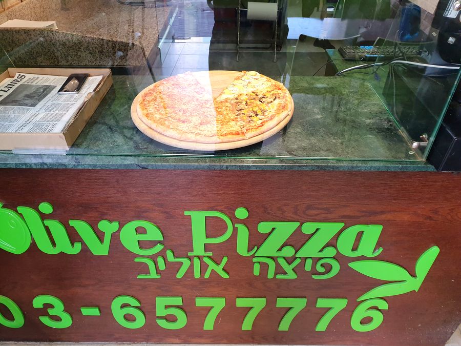 דלפק פיצה אוליב עם השלט של החנות